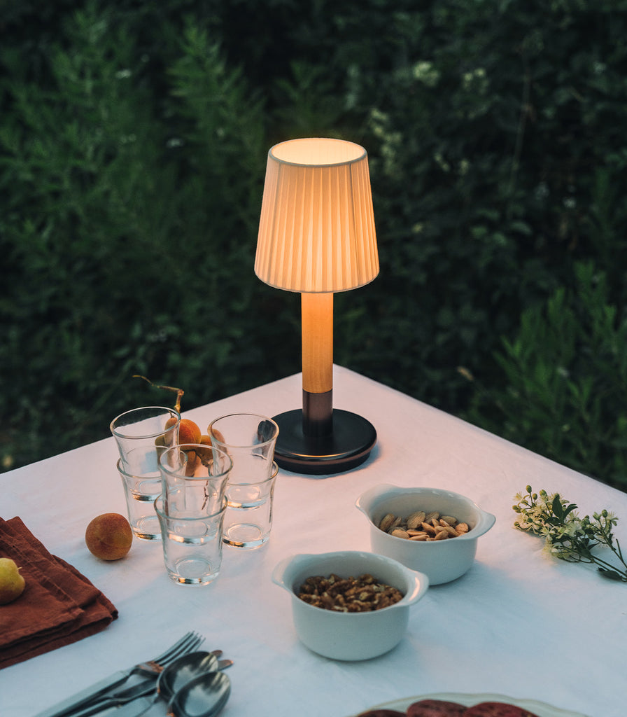 Santa & Cole Basica Minima Portable Table Lamp featured within outdoor space