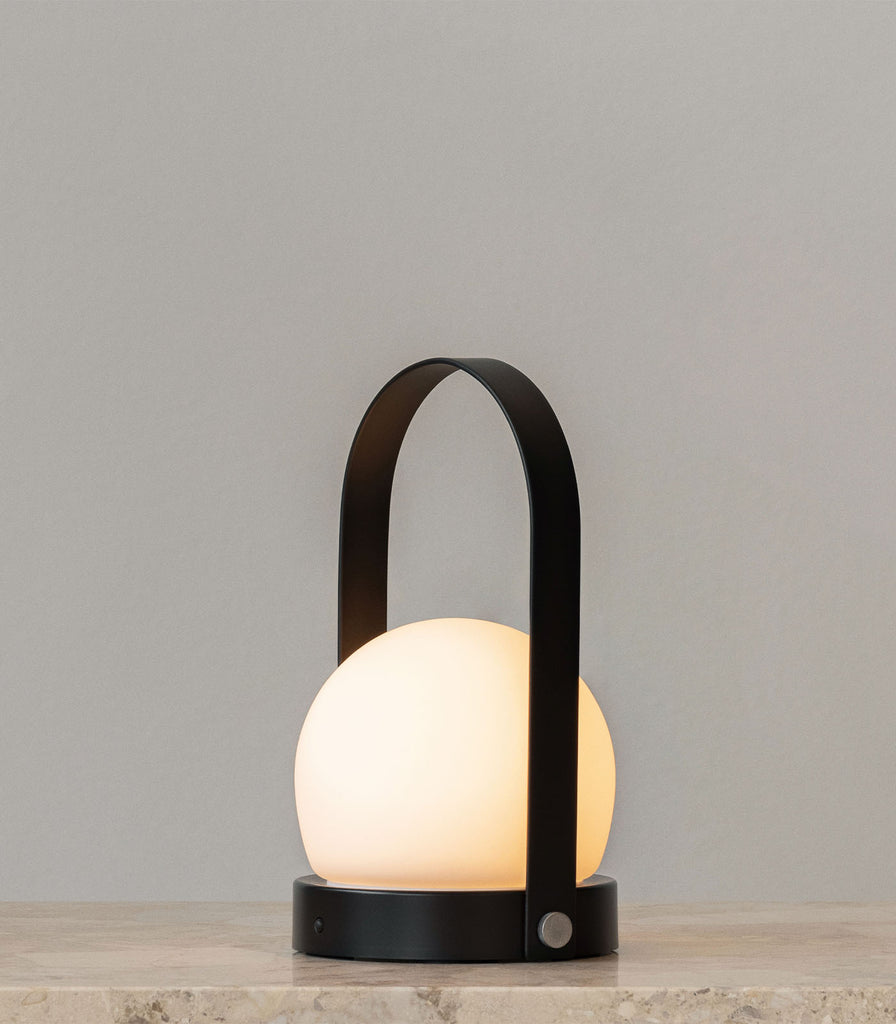 Menu Lighting Carrie Portable Table Lamp featured within interior space