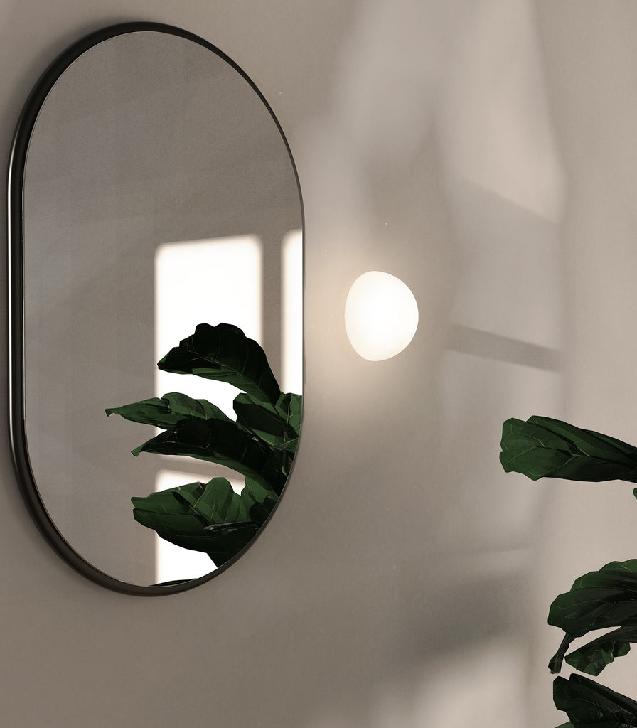 Lighting Republic Orb Dome Mirror Wall Light in white placed beside mirror