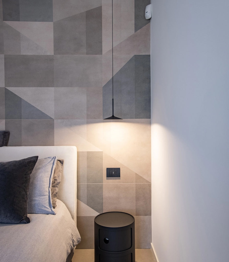 Linea Light Poe Pendant Light hanging over bedside table