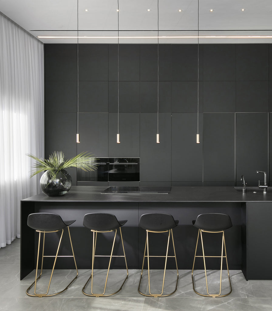 Estiluz Volta Pendant Light in Black/Satin Gold haning over kitchen bench