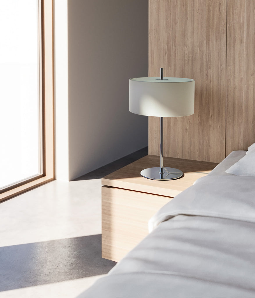 Aromas Mila Table Lamp placed a beside bedside table in Chrome/White