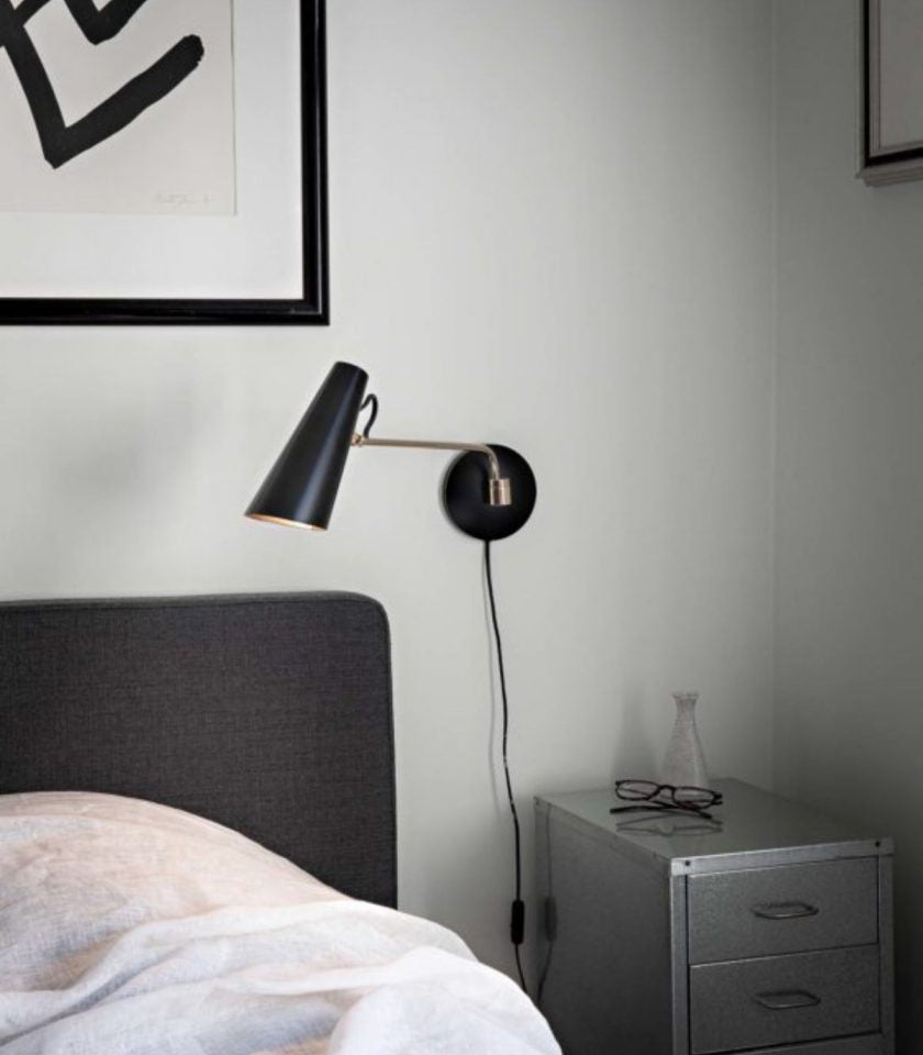Northern Birdy Swing Wall Lamp featured beside a bed