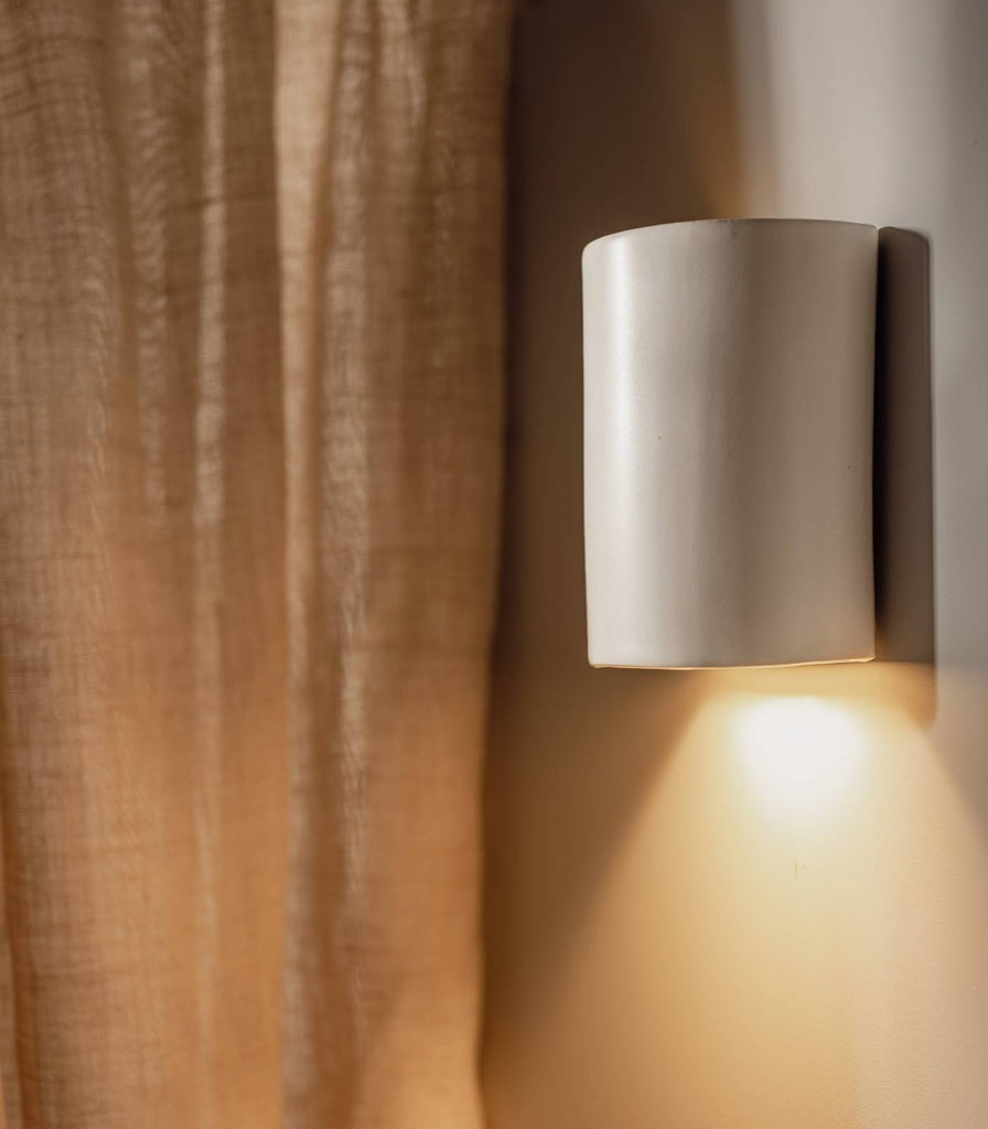 We Ponder Dawn Short Wall Light in Eggshell White turned on