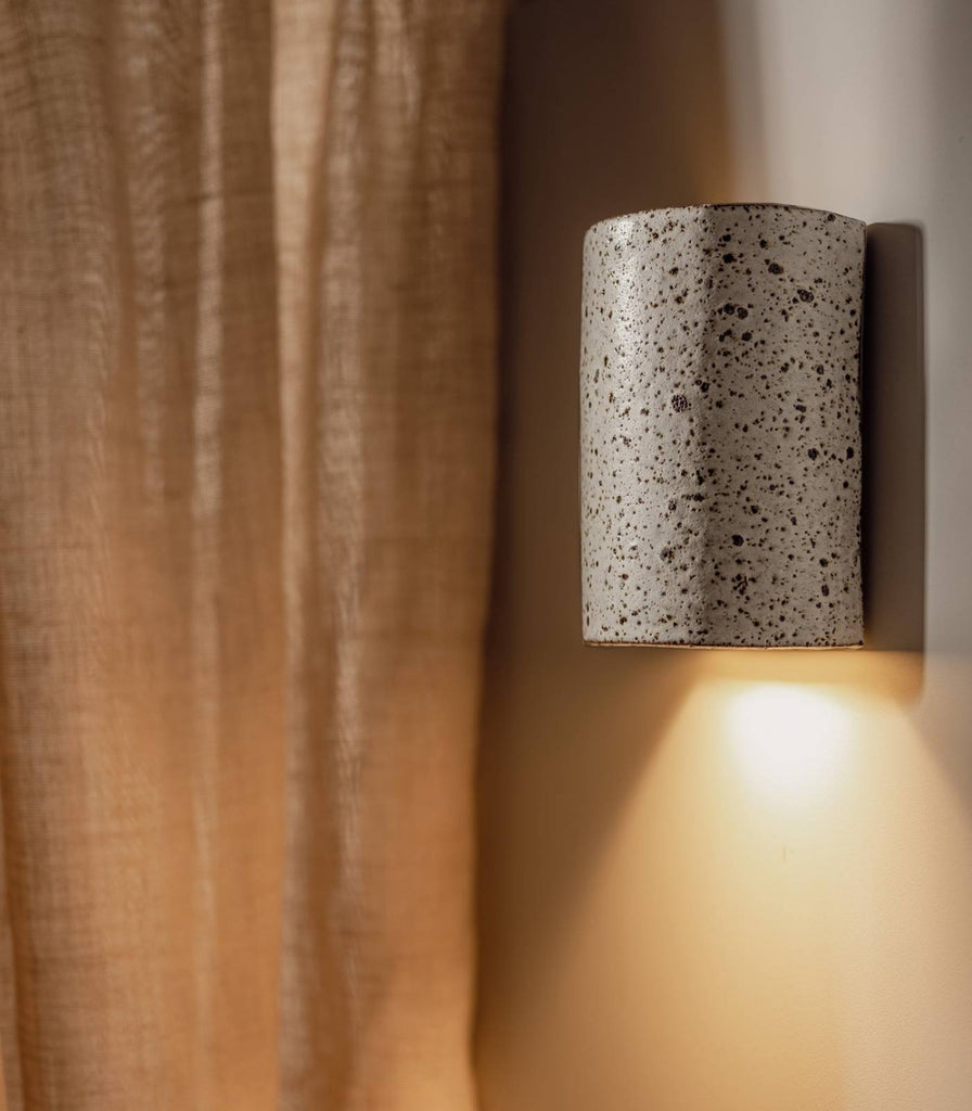 We Ponder Dusk Short Wall Light in Fleck/Eggshell White turned on